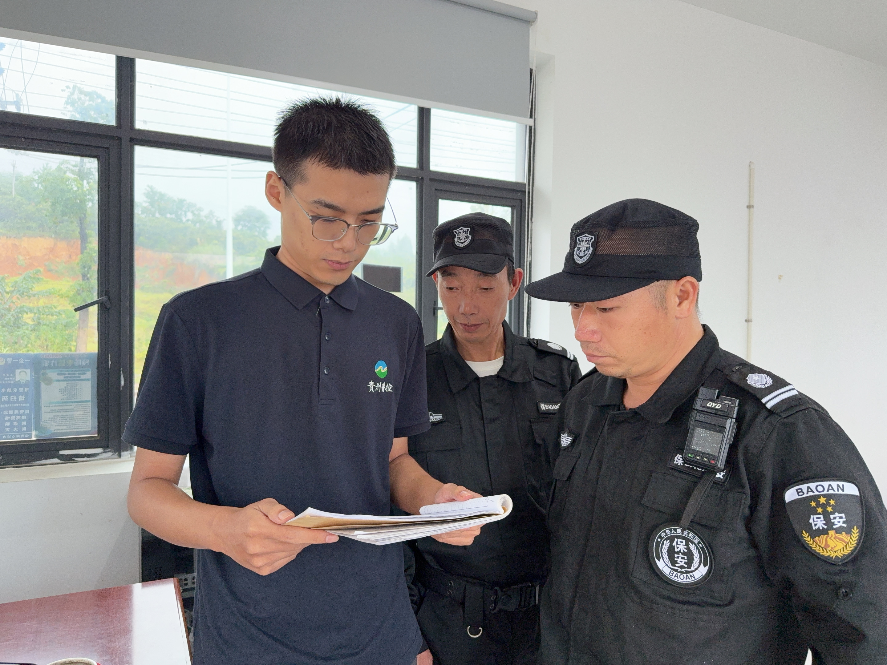 圖為李鵬程檢查進出車輛登記情況.jpg